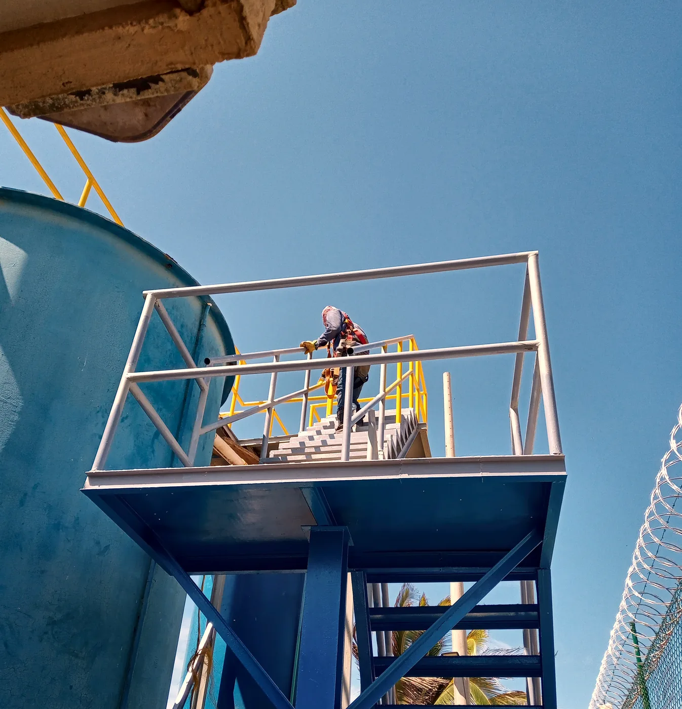 Plataforma de acceso con barandas sobre un tanque de almacenamiento