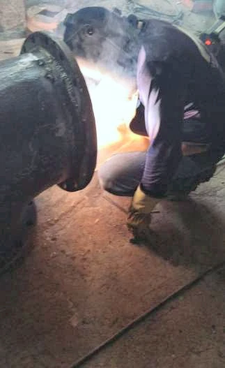Soldador trabajando en la unión del codo