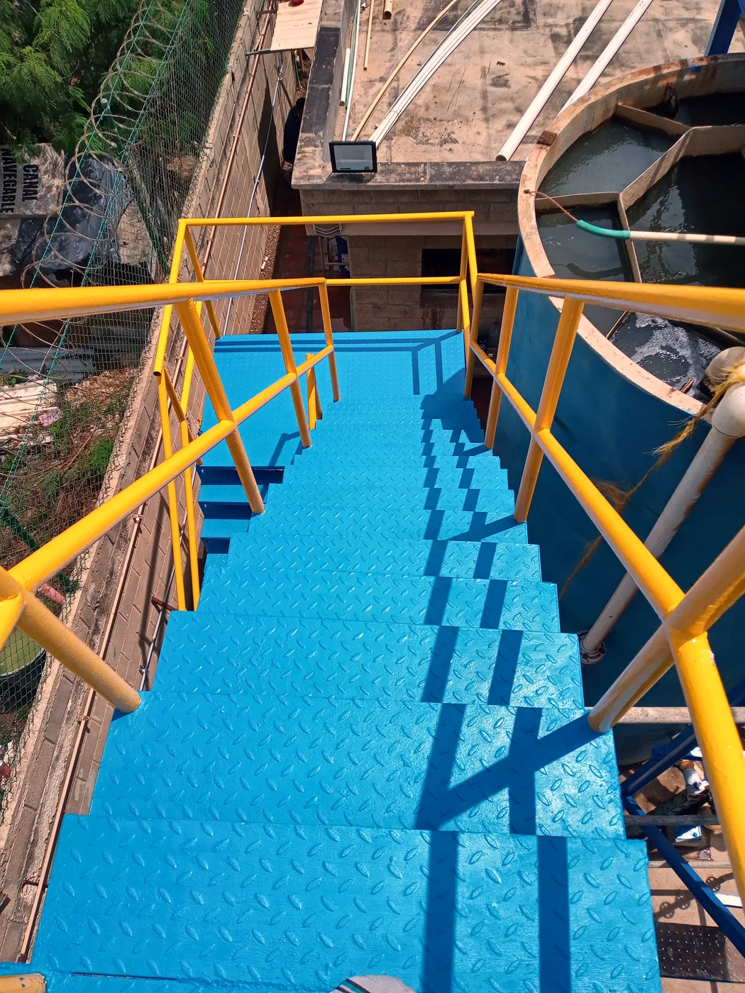 Escalera terminada, pintada de azul con barandas amarillas
